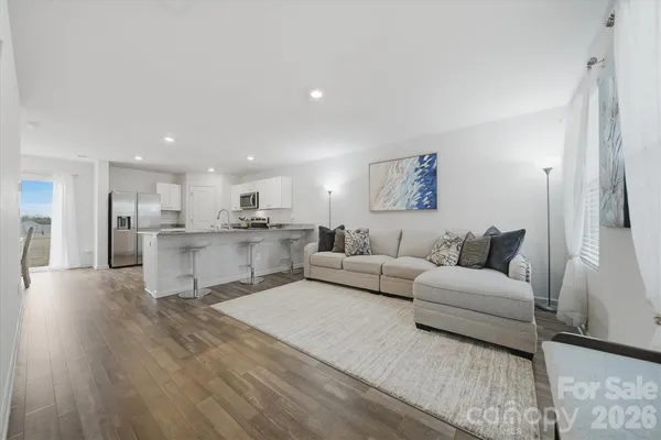 a living room with furniture and kitchen view