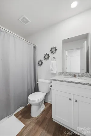 a bathroom with a granite countertop sink a toilet and a mirror