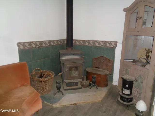 a backyard of a house with table and chairs under a large tree