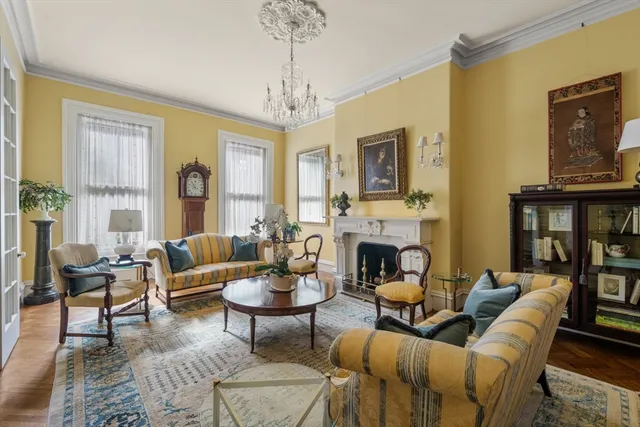a living room with furniture a chandelier and a fireplace