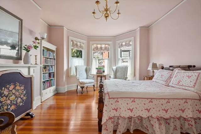 a bedroom with a large bed a chandelier and windows