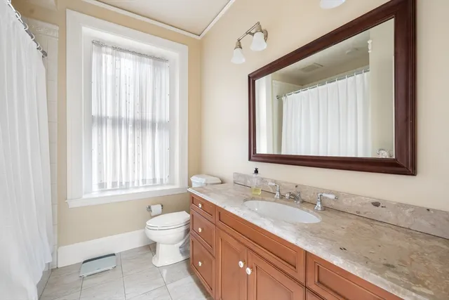 a bathroom with a granite countertop sink toilet and mirror