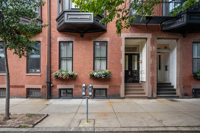 a view of a house with a bench and potted plants