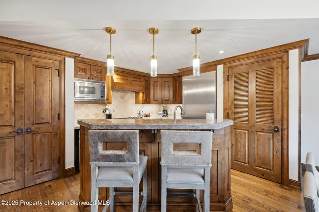 a kitchen with stainless steel appliances granite countertop a sink and refrigerator