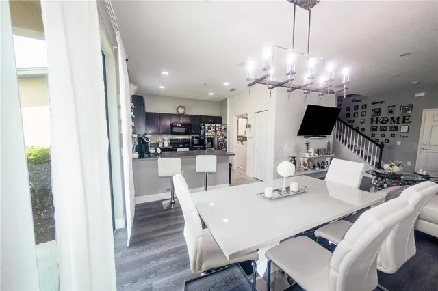 a view of a dining room with furniture a chandelier and wooden floor