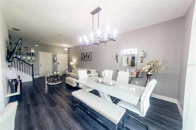 a living room with furniture or chandelier and a wooden floor