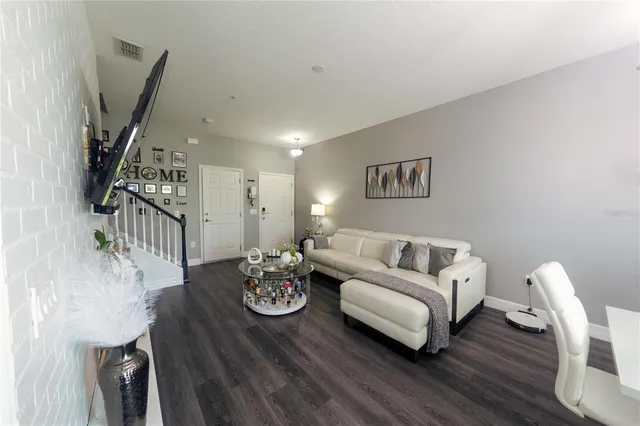 a living room with furniture and wooden floor