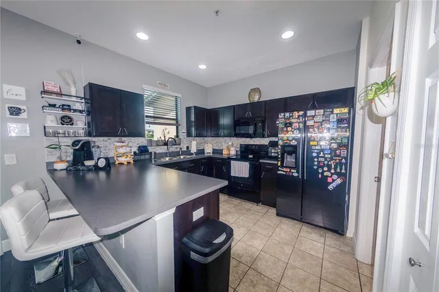 a kitchen with stainless steel appliances granite countertop a sink a stove and a refrigerator
