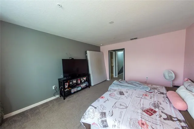 a bedroom with a bed a dresser and a flat screen tv