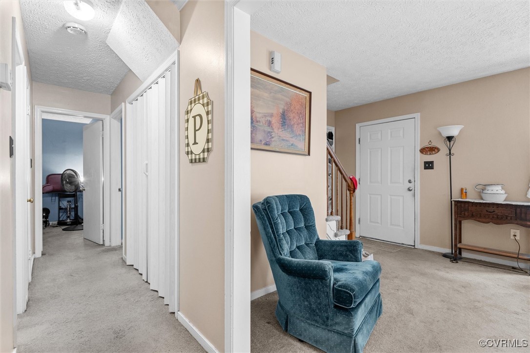 7306 Full Rack Drive Midlothian, VA 23112 - Photo 7 of 32 Hallway with light carpet, a textured ceiling, and