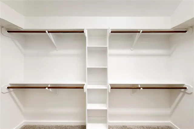 a view of walk in closet with empty racks