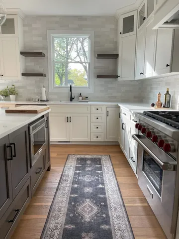 a kitchen with stainless steel appliances granite countertop a stove a sink dishwasher and cabinets with wooden floor