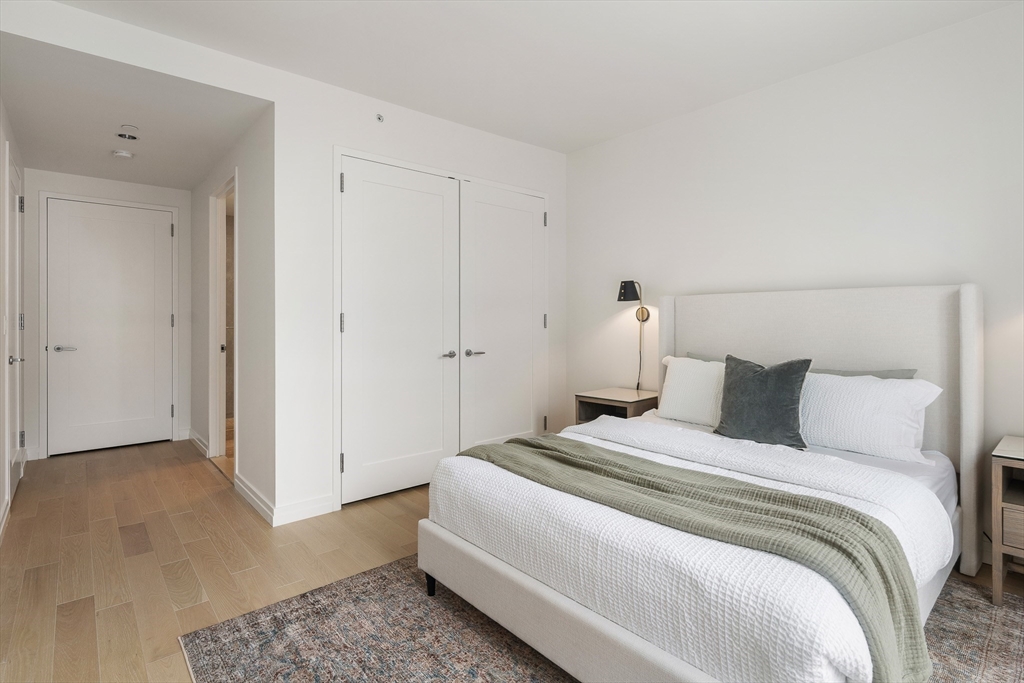 1 Franklin Street, Unit 1506 Boston, MA 02110 - Photo 12 of 32 a bedroom with a bed and a walk in closet