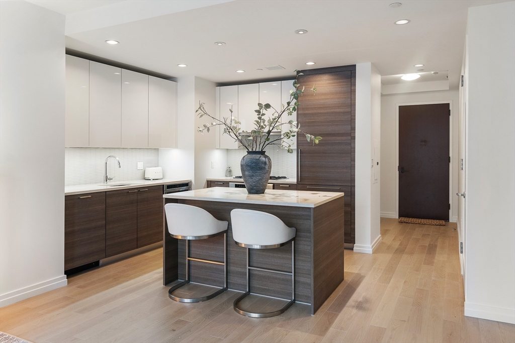 1 Franklin Street, Unit 1506 Boston, MA 02110 - Photo 3 of 32 a kitchen with a sink cabinets and wooden floor