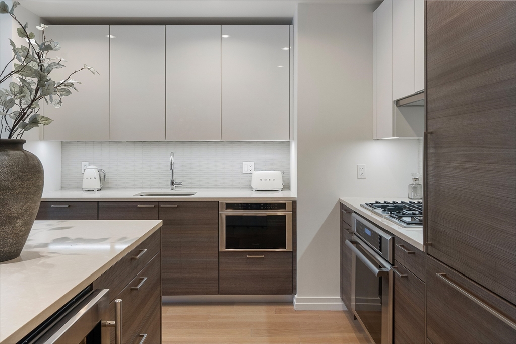 1 Franklin Street, Unit 1506 Boston, MA 02110 - Photo 4 of 32 a kitchen with a sink stove and cabinets
