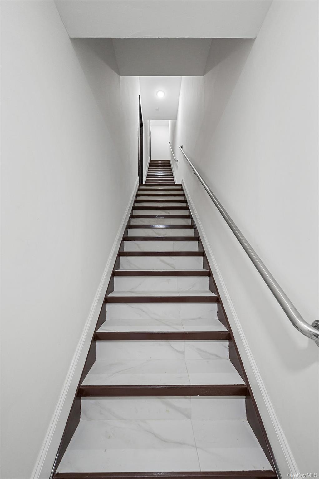10603 49th Avenue Queens, NY 11368 - Photo 22 of 32 Stairs featuring inlaid floor details, marble finish flooring, and recessed lighting