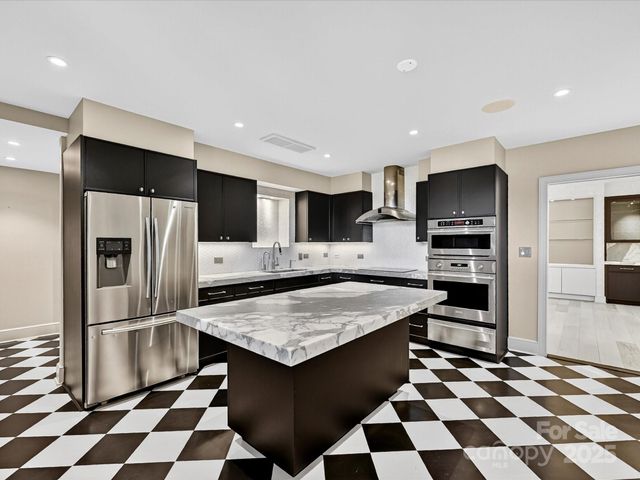 a kitchen with stainless steel appliances a sink stove and refrigerator