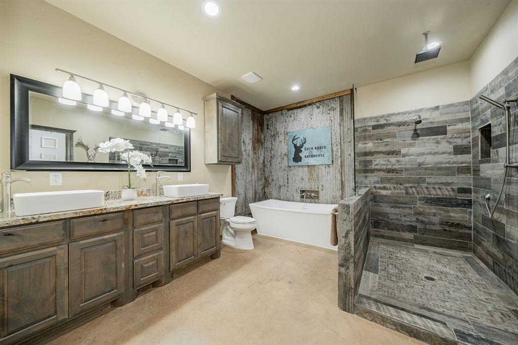 1990 Jim Harry Loop Sunset, TX 76270 - Photo 19 of 40 a bathroom with a bathtub shower sink and mirror