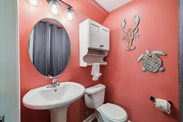 a bathroom with a toilet sink and mirror