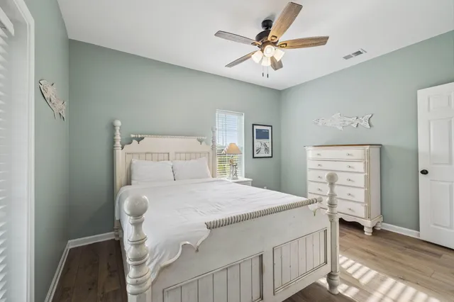 a bedroom with a bed a chandelier and a dresser
