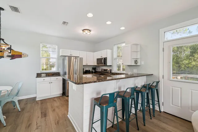 a kitchen with refrigerator stove and wooden floor