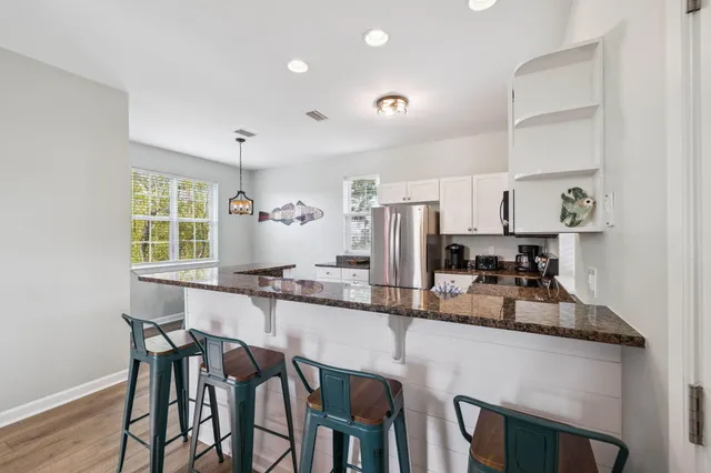 a kitchen with stainless steel appliances granite countertop a stove a sink dishwasher a dining table and chairs