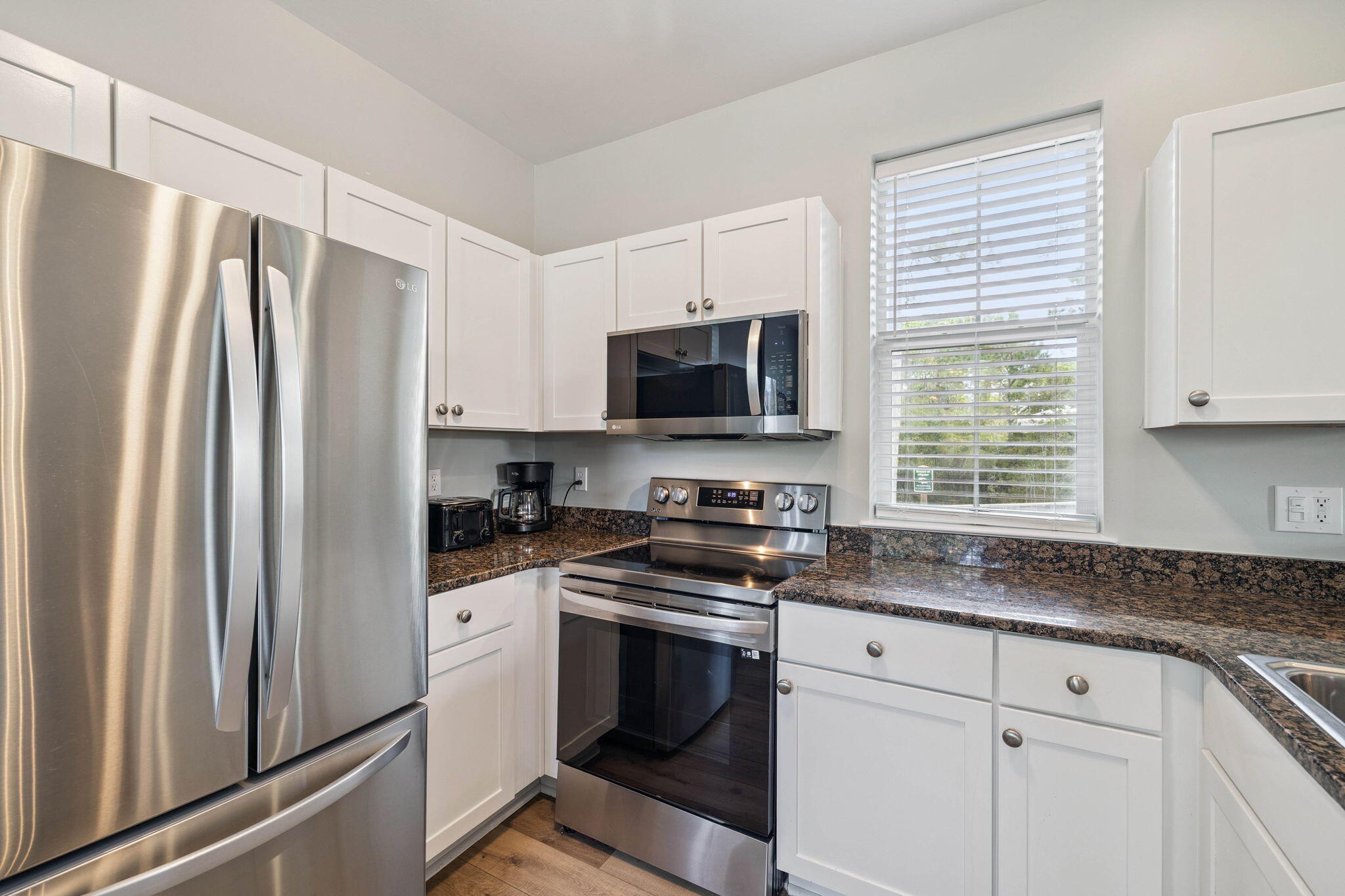 198 Somerset Bridge Road, Unit 114 Santa Rosa Beach, FL 32459 - Photo 6 of 28 a kitchen with stainless steel appliances white cabinets and a refrigerator