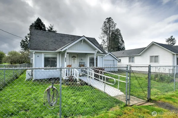 a view of house with a yard and deck