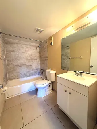 a bathroom with a granite countertop sink mirror vanity and toilet
