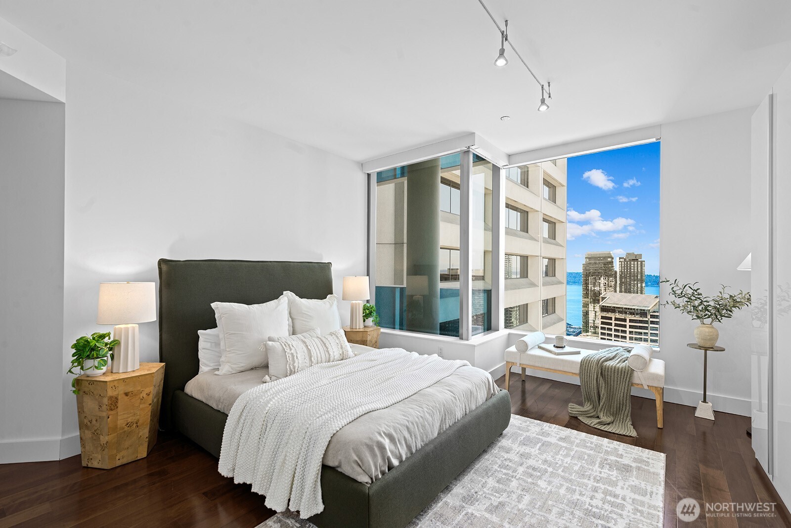 737 Olive Way, Unit 3509 Seattle, WA 98101 - Photo 15 of 31 a spacious bedroom with a bed and wooden floor
