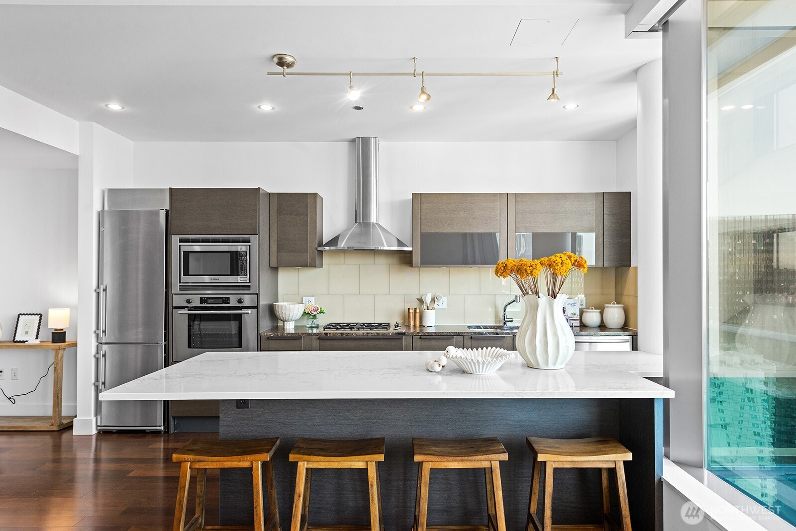 737 Olive Way, Unit 3509 Seattle, WA 98101 - Photo 10 of 31 a kitchen with stainless steel appliances a sink and wooden cabinets