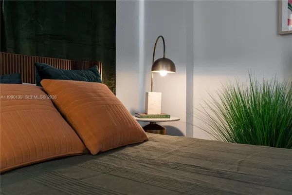 a bedroom with a bed and a potted plant