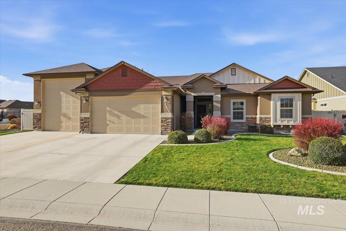 4604 Middlesboro Way Caldwell, ID 83607 - Photo 1 of 43 Craftsman-style home with stone siding, an attached garage, concrete driveway, and a front yard