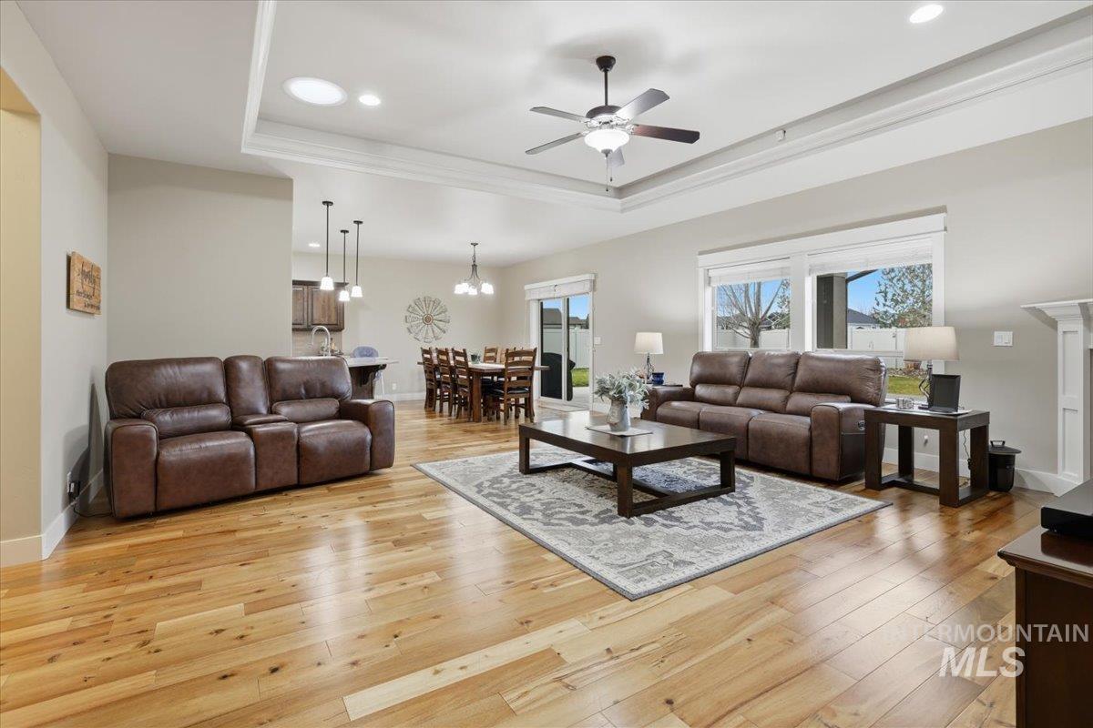 4604 Middlesboro Way Caldwell, ID 83607 - Photo 10 of 43 Living room featuring ceiling fan, a tray ceiling, light wood-style flooring, recessed lighting, and crown molding