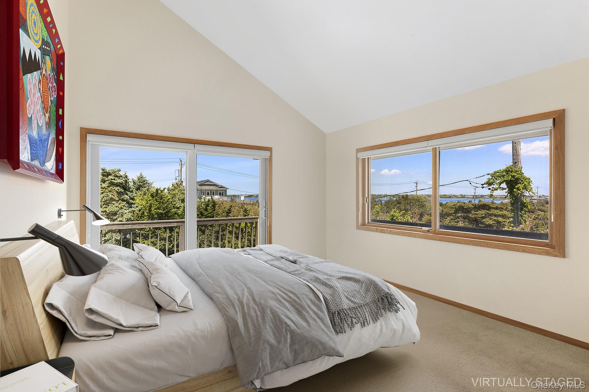 63-65 Dune Road Quogue, NY 11959 - Photo 12 of 29 a bed sitting in a bedroom next to a window