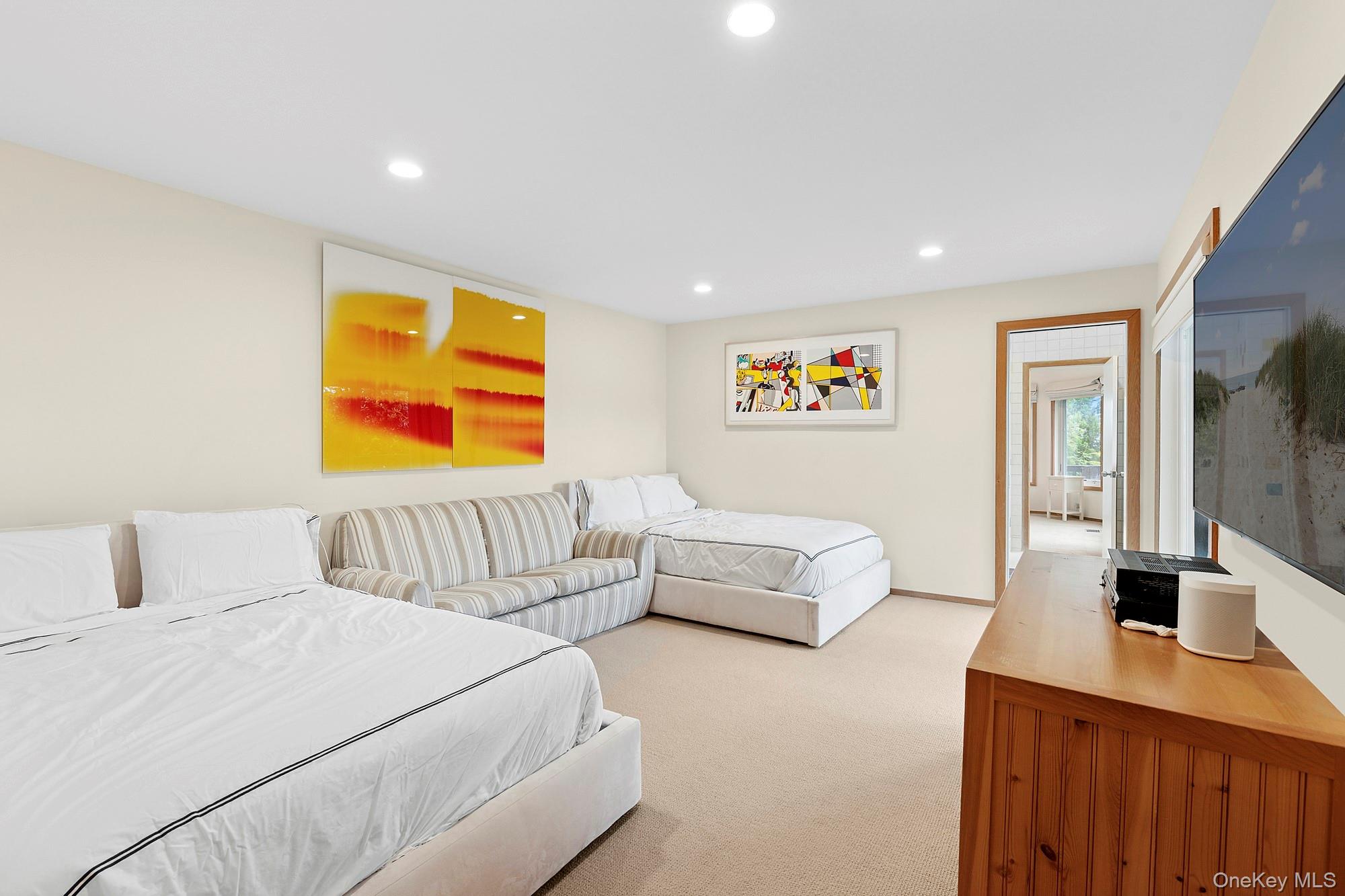 63-65 Dune Road Quogue, NY 11959 - Photo 16 of 29 a bedroom with a bed and couch