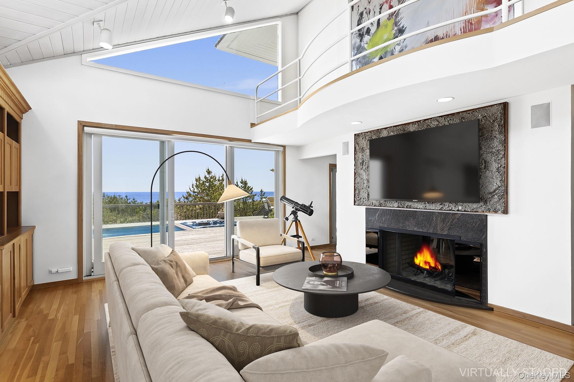 63-65 Dune Road Quogue, NY 11959 - Photo 3 of 29 a living room with furniture and a fireplace