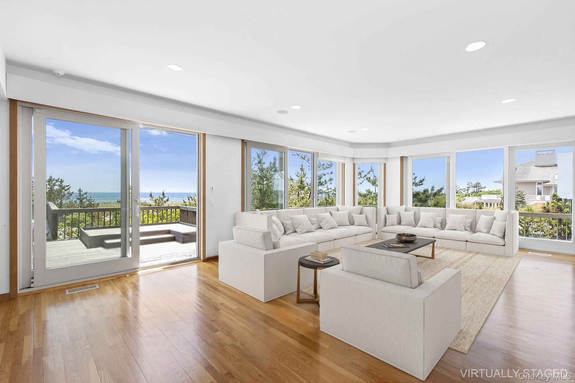 63-65 Dune Road Quogue, NY 11959 - Photo 4 of 29 a living room with furniture large windows and wooden floor