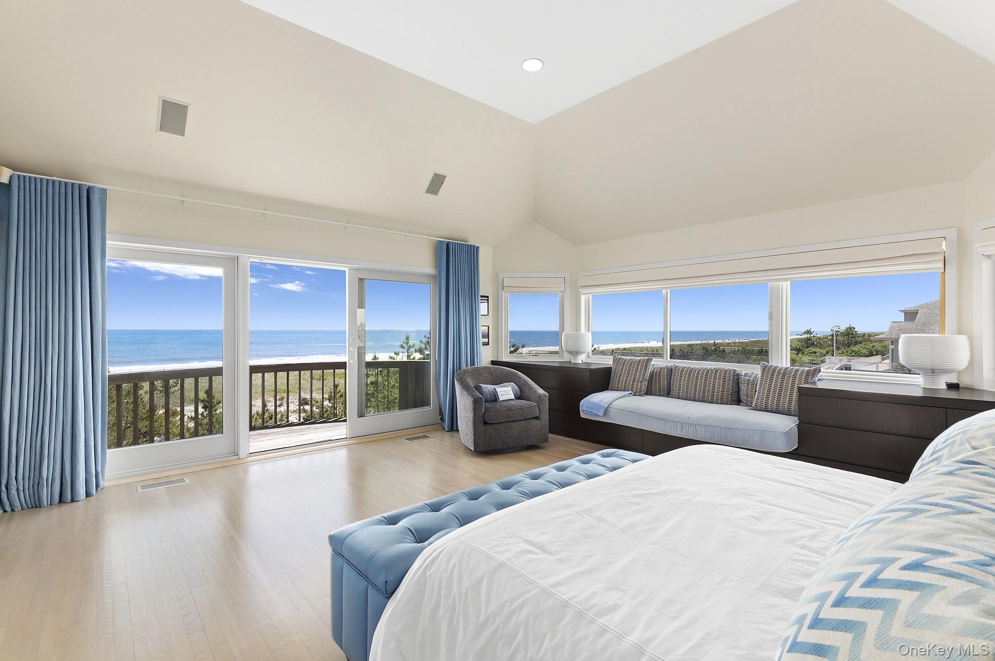 63-65 Dune Road Quogue, NY 11959 - Photo 9 of 29 a bedroom with two large bed and a large window