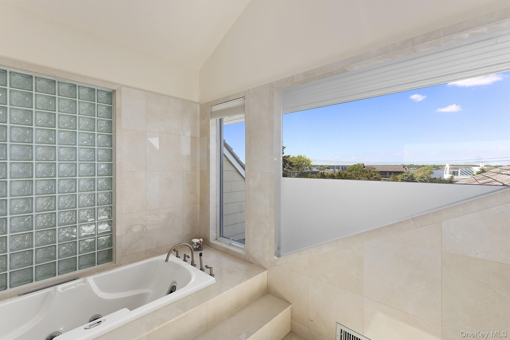 63-65 Dune Road Quogue, NY 11959 - Photo 10 of 29 a bathroom with a bathtub and a sink