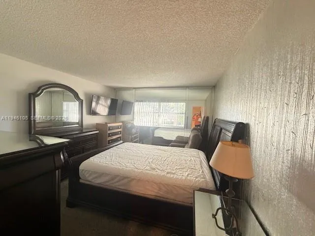 a bedroom with a bed window and dresser