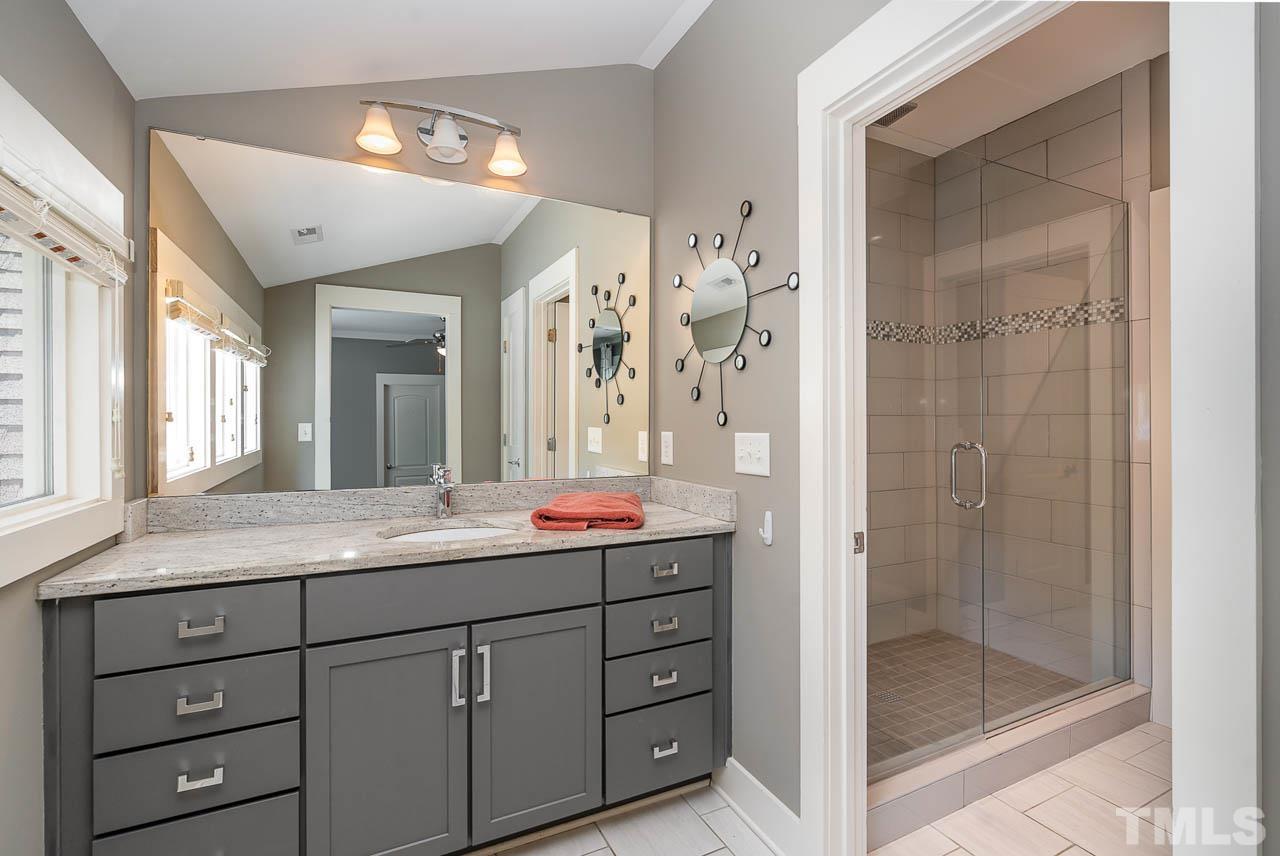 8615 Oneal Road Raleigh, NC 27613 - Photo 38 of 58 a bathroom with a granite countertop sink mirror and shower
