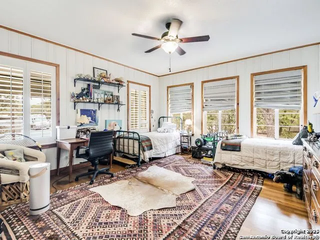 a living room with furniture ceiling fan and a large window