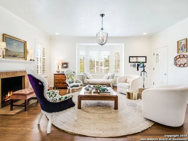 a living room with fireplace furniture and a large window
