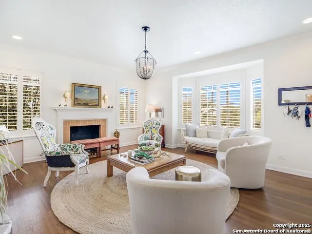 a living room with furniture a fireplace and a large window