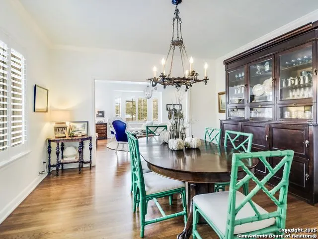 a view of a dining room with furniture a chandelier and wooden floor