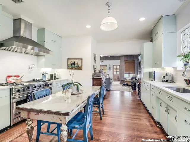 a large kitchen with kitchen island a stove a table and chairs in it