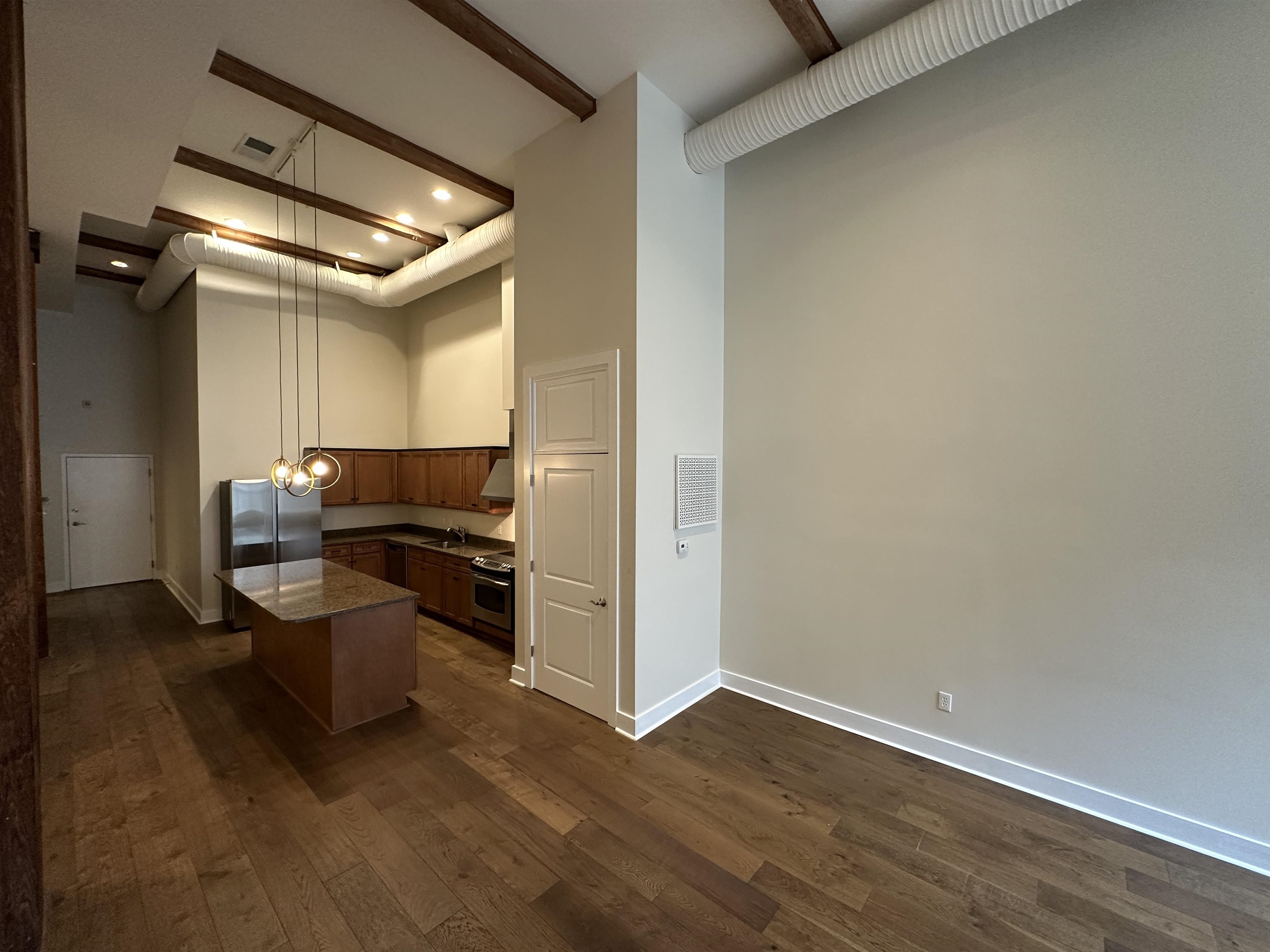 435 South Front Street, Unit 109 Memphis, TN 38103 - Photo 15 of 25 Kitchen with a center island, decorative light fixtures, dark wood-type flooring, and stainless steel appliances