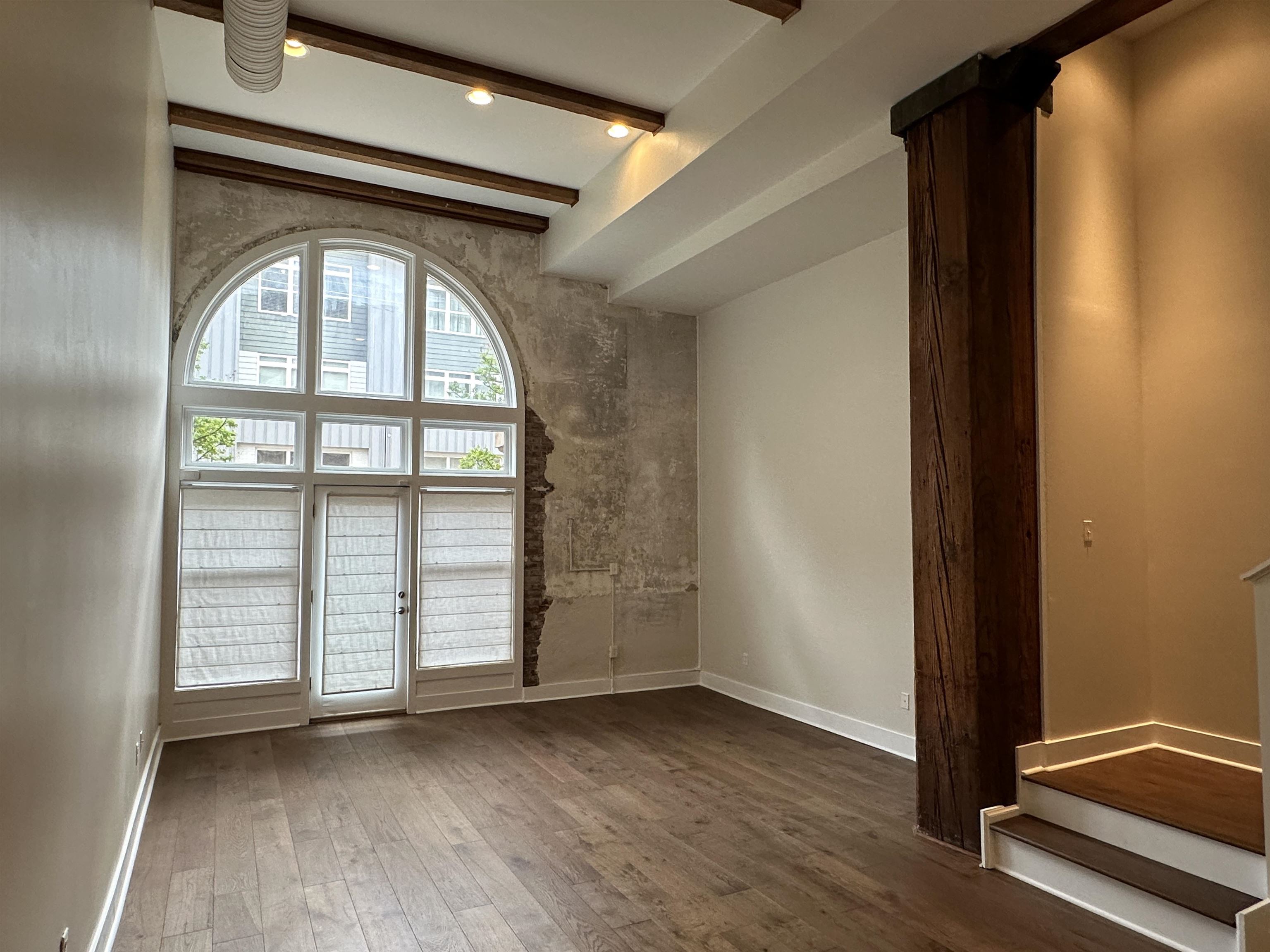 435 South Front Street, Unit 109 Memphis, TN 38103 - Photo 4 of 25 Unfurnished room with dark wood finished floors and beam ceiling