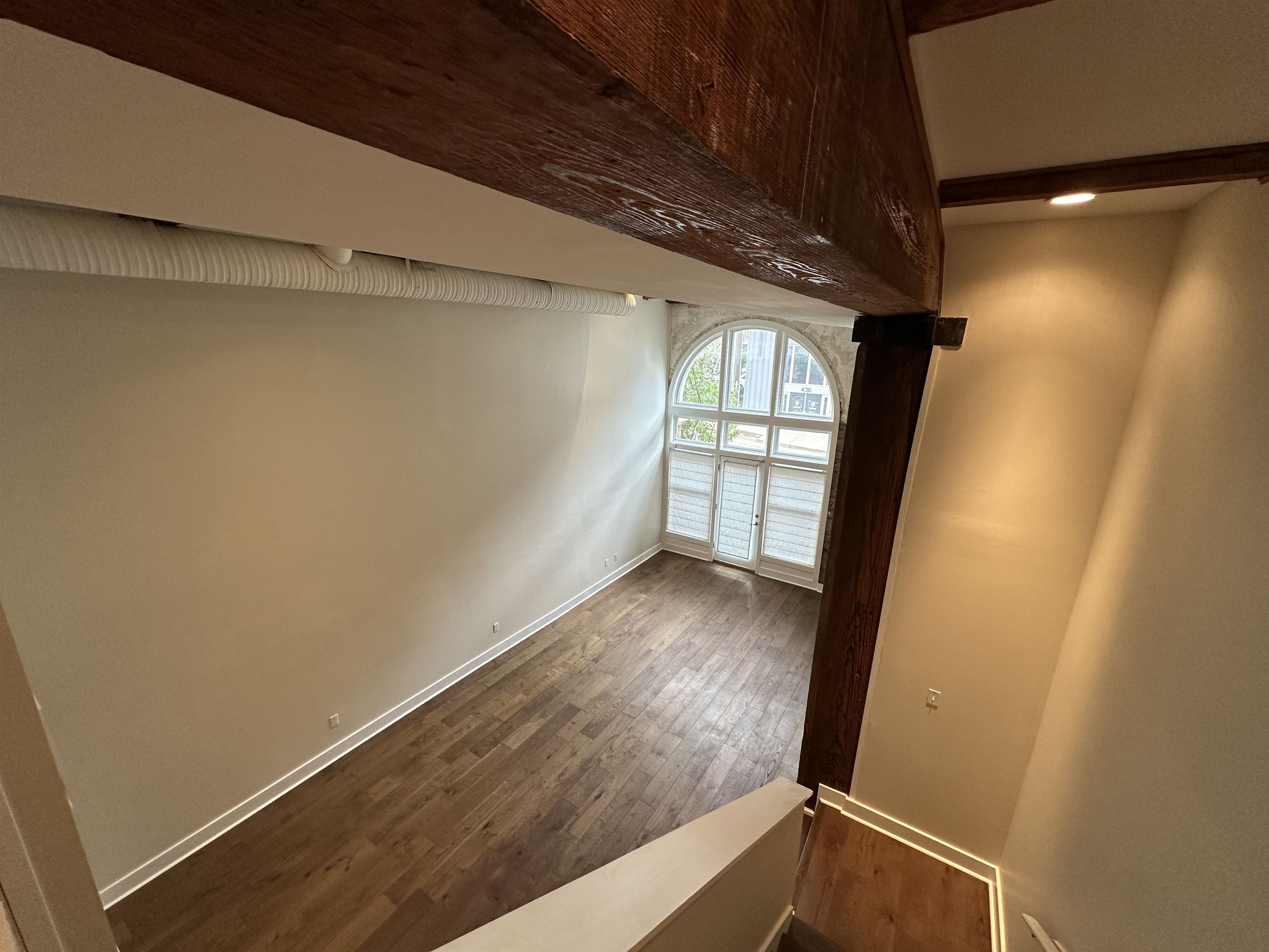 435 South Front Street, Unit 109 Memphis, TN 38103 - Photo 5 of 25 Empty room featuring beamed ceiling and dark wood-type flooring